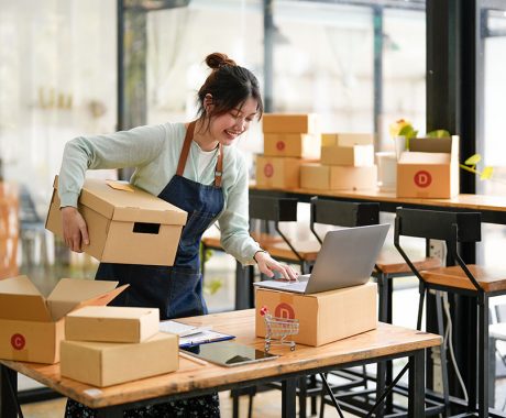 Startup small business SME, Entrepreneur owner using laptop computer taking receive and checking online purchase shopping order to preparing pack product box. Selling online ideas concept.
